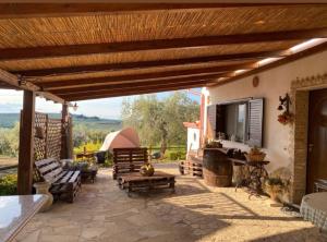 an outdoor patio with a television and a couch and chairs at FATTORIA ROVELLO in San Paolo di Civitate