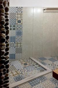 a bathroom with a shower with blue and white tiles at Saxonis Houses & Saxonis Villa in Papingo