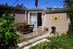 a patio with a sun painted on the side of a house at Field's Rest in Port Elizabeth
