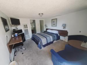 Habitación de hotel con cama, escritorio y escritorio. en Holiday Lodge, en Sheridan