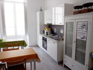 a small kitchen with white cabinets and a table and a tableablish at Sicania in Patti