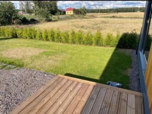 Elle offre une vue sur une cour avec une terrasse en bois. dans l'établissement Modern accommodation close to lake and nature, à Köyliö