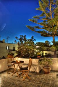 納烏薩的住宿－安娜膳食公寓旅館，一个带桌椅和棕榈树的庭院