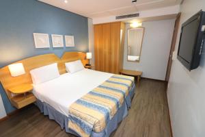 เตียงในห้องที่ Hotel Nacional Inn São José dos Campos