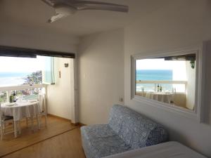 a living room with a couch and a view of the ocean at Estudio Nefeli in Benalmádena