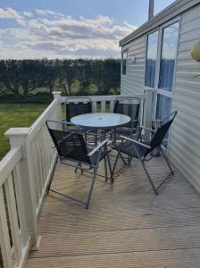 un patio con mesa y sillas en una terraza en 64 Southfield - Skipsea Sands en Ulrome