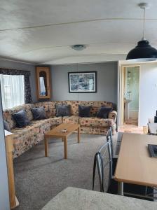 a living room with a couch and a table at 64 Southfield - Skipsea Sands in Ulrome