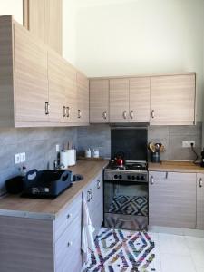 una cucina con armadi in legno e piano cottura. di Spacious Beach House Theologos a Theologos