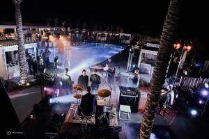 a group of people standing around a pool at night at 800s Home Luxury Rooms in Ostuni