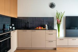 a kitchen with white cabinets and a clock on the wall at apartamenty-wroc Kurkowa in Wrocław