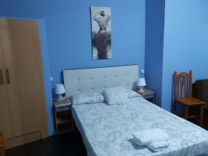 a blue room with a bed with two towels on it at Hostal Porta De Núria in Ribes de Freser