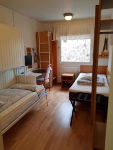 a bedroom with two beds and a desk in it at Håknäs Vandrarhem in Järna