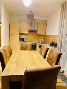a kitchen with a wooden table and some chairs at RIVIERA LIPNO 502 Apartmán 4kk u vody in Lipno nad Vltavou