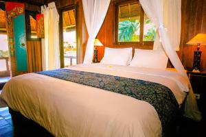ein Schlafzimmer mit einem großen weißen Bett mit einem Fenster in der Unterkunft Radiant Jepun Villa in Legian + 37 Fotos