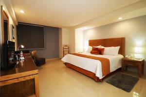 a hotel room with a bed and a flat screen tv at HB Córdoba in Córdoba