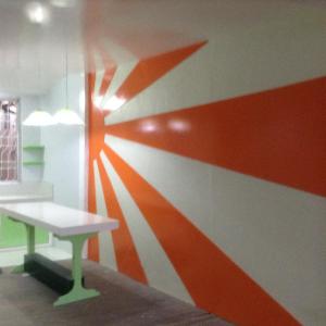 a room with a red and white wall with a table at Lavarez Apartment in Lucena