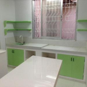 a bathroom with green and white counters and a window at Lavarez Apartment in Lucena