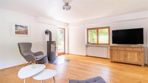 a living room with a television and a chair at Ferienhaus Achental in Schleching