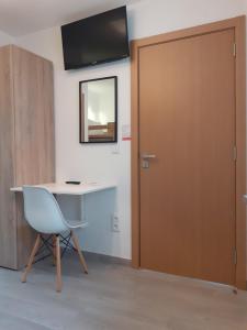 Una puerta en una habitación con escritorio y silla en Hostel Sertã, en Sertã