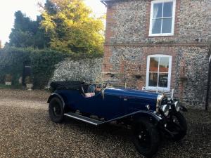 een oude blauwe auto geparkeerd voor een gebouw bij Grange Farm in Thetford