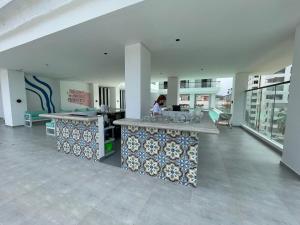 a woman sitting at a counter in a building at 3H Hotel Rodadero SANTA MARTA in Santa Marta