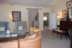 a living room with a couch and chairs and a piano at Grange Farm in Thetford