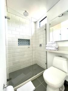 a bathroom with a toilet and a glass shower at 3H Hotel Rodadero SANTA MARTA in Santa Marta