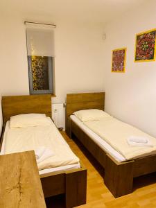 two twin beds in a room with a table at RIVIERA LIPNO 502 Apartmán 4kk u vody in Lipno nad Vltavou