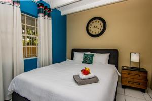 um quarto com uma cama com um relógio na parede em CityLife Apartments in Willemstad - groundfloor 2 bedroom apartment - C em Willemstad
