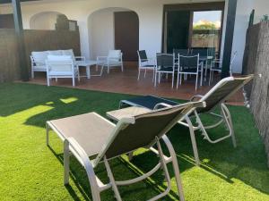 un grupo de sillas y mesas en un patio en Jardines de Nuevo Vera - Magnífico Apartamento a Pie de Playa, en Vera