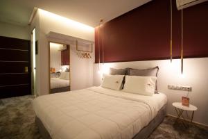 um quarto com uma cama grande e almofadas brancas em X Dream Hotel-Adults Only em Atenas