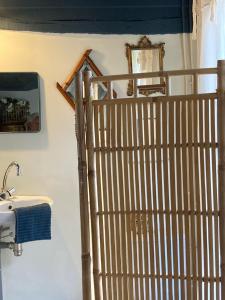 a wooden gate in a bathroom with a sink at La Ferme du Val de Lys in Nolléval