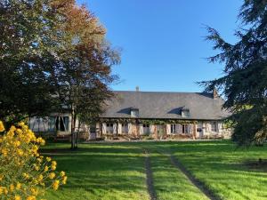 a large house with a green yard with trees at La Ferme du Val de Lys in Nolléval