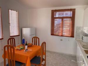 a kitchen with a table with chairs and a refrigerator at Sol y Mar in Tarajalejo +10 photos