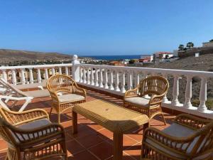 a group of chairs and tables on a balcony at Sol y Mar in Tarajalejo