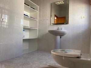 a white bathroom with a toilet and a sink at Sol y Mar in Tarajalejo