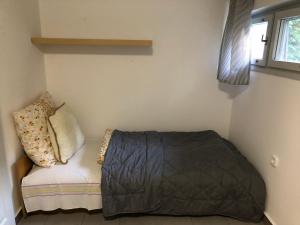 1 dormitorio pequeño con 1 cama y 1 sofá en Iker Nyaraló Balatonfenyves, en Balatonfenyves