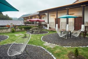 um pátio com uma mesa, cadeiras e um guarda-sol em Hotel Vintage "Rialto" em Quetzaltenango