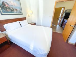 Lake Bluff Inn and Suites في ساوث هافن: سرير أبيض كبير في غرفة الفندق