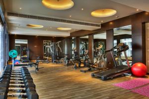 a gym with treadmills and elliptical machines at Golden Tulip Bhiwadi in Dhāruhera