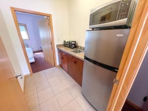 a kitchen with a stainless steel refrigerator with a microwave at Lake Bluff Inn and Suites in South Haven