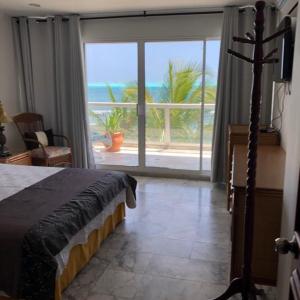 1 dormitorio con cama y vistas al océano en Apartamento Vacacional en Sun Rise San Andrés con Playa Privada, en San Andrés