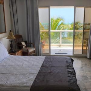 1 dormitorio con cama y vistas a una palmera en Apartamento Vacacional en Sun Rise San Andrés con Playa Privada en San Andrés