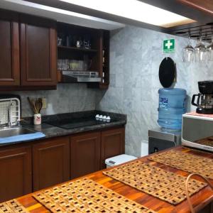 cocina con armarios de madera y encimera en Apartamento Vacacional en Sun Rise San Andrés con Playa Privada en San Andrés