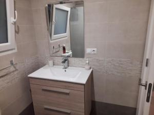 une salle de bain avec un lavabo et un miroir dans l'établissement Apartamento 2 playa Riberuca Suances, à Suances 11 autres photos