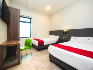 a hotel room with two beds and a television at Hotel Río in Puebla