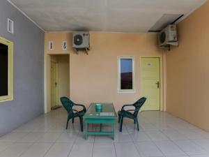 um quarto com uma mesa e cadeiras num quarto em OYO 3907 Mine Residence em Padang