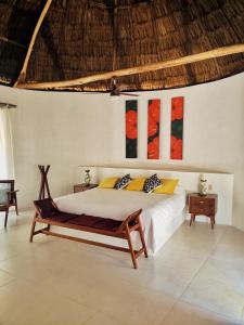 um quarto com uma cama e um banco em Hotel B. Secreto Maya em Yaxché