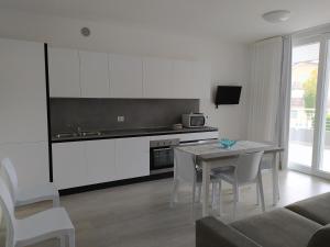 a living room with a table and a kitchen at Jesolo Appartamenti F2 - Light Blue in Lido di Jesolo