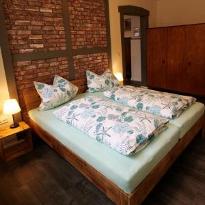 a bed in a room with a brick wall at Barrierefreie Unterkunft - Fachwerk mit Flair in Osterode